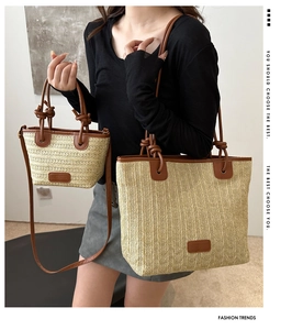 Detailansicht der gewebten Stroh-Tote-Bags mit braunem Lederbesatz und Knotengriff-Design