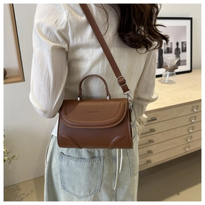 Detail der karamellbraunen PU-Ledertasche mit FASHION & BAG Prägung und runder Steppung