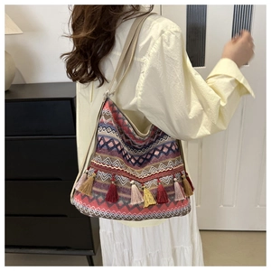 Detail of bohemian tote with colorful geometric woven patterns and vibrant tassel fringe