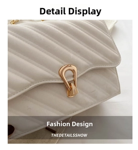 Close-up of white quilted crossbody bag featuring golden U-shaped buckle and chain strap