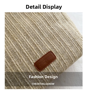 Detailed macro view of woven straw texture and premium brown leather logo patch on tote bag