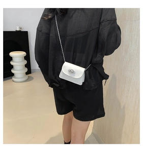 Rear view of a white mini crossbody bag with a planet buckle and metal chain strap