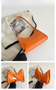 Detail view of glossy orange patent leather shoulder bag with zipper and stitching