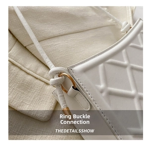 Gros plan d'un sac à main blanc matelassé avec surpiqûres et boucle anneau dorée chic