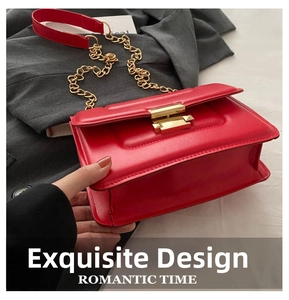 Close-up of red leather flap bag with gold metal buckle and elegant chain strap