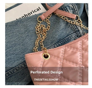 Detailed close-up of pink quilted tote bag with gold chain strap on denim fabric
