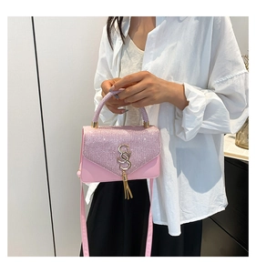 Detailed view of a pink sequin crossbody bag featuring metal tassels and a gold double S buckle