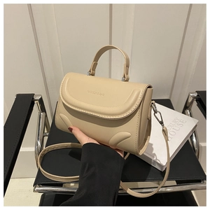 Details der beigen PU-Lederhandtasche mit silbernen Beschlägen und geprägtem Text