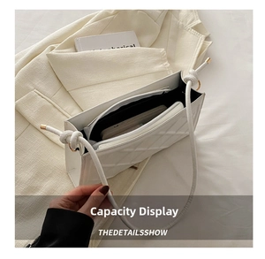 Vue détaillée de l'intérieur spacieux d'un sac à bandoulière matelassé blanc en similicuir