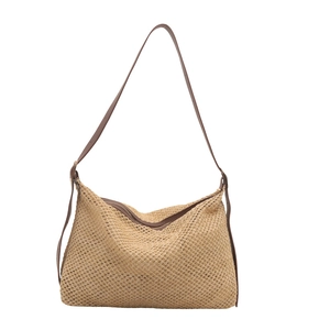 Handwoven straw tote bag with brown leather straps and adjustable buckles in beige