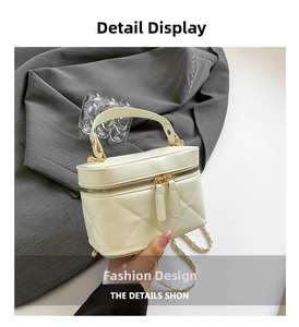 Macro shot of quilted cream leather mini bag featuring metal chain and double zipper