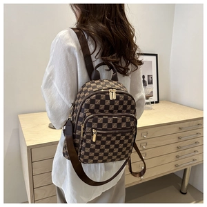Detail of checkered plaid backpack with gold zipper and adjustable shoulder strap