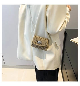 Detail of the silver Saturn-shaped orb buckle and M-letter monogram print on a mini bag