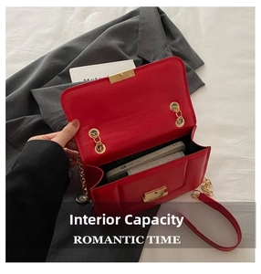 Macro view of red flap shoulder bag showing internal capacity for phone and cards