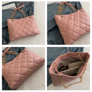 Detail view of pink quilted tote bag with gold chain strap and interior storage pockets