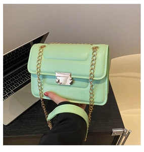 Detailed macro view of mint green quilted chain shoulder bag with silver square clasp