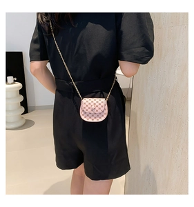 Rear view of model wearing pink mini saddle crossbody bag with retro floral print and chain