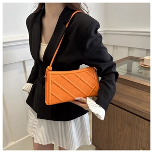 Gros plan du sac à bandoulière matelassé orange vif avec détail de nœud élégant