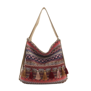 Ethnic woven tote bag with bohemian patterns and colorful tassels on white background