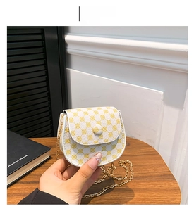 Detailed close-up of a mini crossbody bag with yellow clover patterns and gold chain
