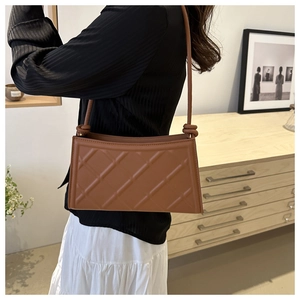 Sac à bandoulière matelassé marron avec détail de nœud et style minimaliste chic