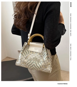 Detail of vintage bucket bag with traditional embroidery and amber resin handle texture