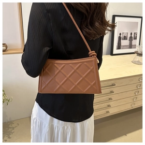 Detail of caramel brown rectangular shoulder bag with large diamond lattice texture
