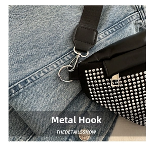 Détail du sac à bandoulière noir avec strass argentés et mousqueton métallique