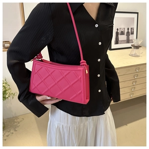 Gros plan sur le sac à bandoulière rose vif avec motif matelassé 3D et détail de nœud