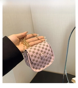 Close-up of pink mini crossbody bag with vintage floral print and gold chain strap
