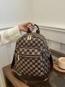 Classic checkered brown multi-functional women's backpack on a wooden table with coffee cup
