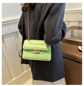Detailed view of the light green quilted leather bag with a gold chain strap and metal clasp