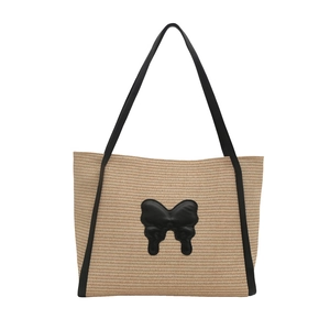 Stylish woven straw tote bag with black butterfly patch and shoulder straps