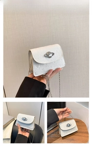 Detail of white monogram handbag with metallic saturn hardware and slim chain strap