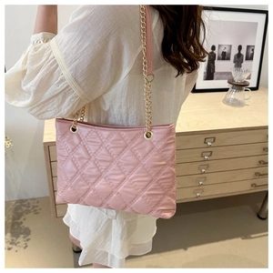Detailed shot of pink quilted tote bag with diamond stitching and gold chain strap