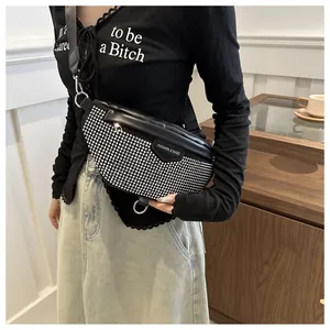 Detail of black crossbody chest bag featuring silver rivet studs and adjustable strap