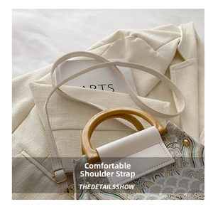 Close-up of vintage bucket bag embroidery with resin handle and adjustable strap