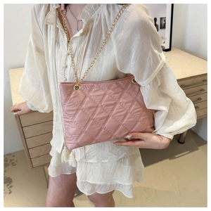 Detail of pink quilted puffer shoulder bag with gold chain strap and diamond stitch texture