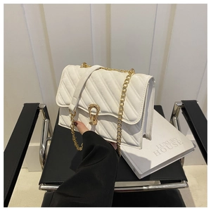 Close-up of white quilted leather bag featuring a gold chain strap and metal clasp