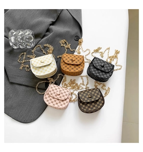 Flat lay of five mini crossbody chain bags with retro monogram print and gold metal straps