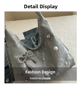 Detailed view of tote bag featuring pearl accents, rhinestone heart, and butterfly charm
