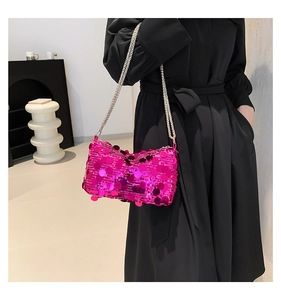 Close-up of bright magenta sequin handbag featuring a metallic silver chain strap for women