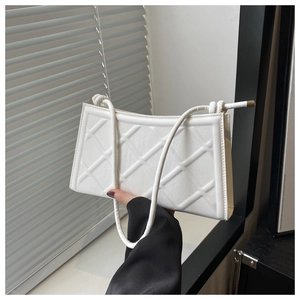Détail du sac matelassé blanc avec poignée nouée minimaliste et texture en cuir PU