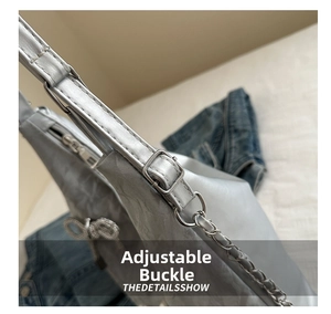 Close-up of adjustable silver buckle and metal chain strap on a crinkled tote bag