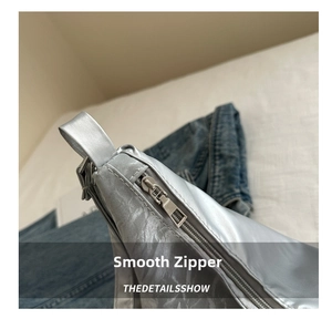 Close-up of smooth silver metal zipper and reflective texture on a large capacity bag