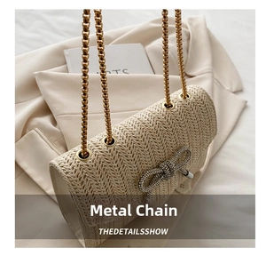 Détail du nœud en strass et de la chaîne métallique sur le sac en paille tissée
