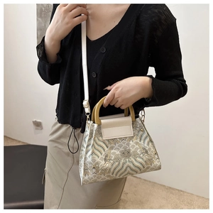 Detailed shot of retro embroidered bucket bag with ocean wave pattern and wooden handles