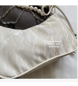 Détail du sac à main motif marbre blanc avec anse en perles et fine chaîne argentée
