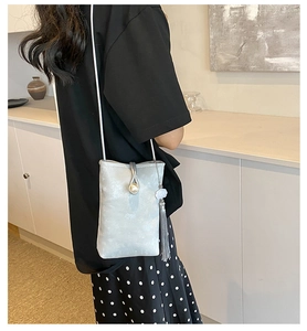 Detail of silver phone crossbody bag with pearl buckle and elegant tassel charm