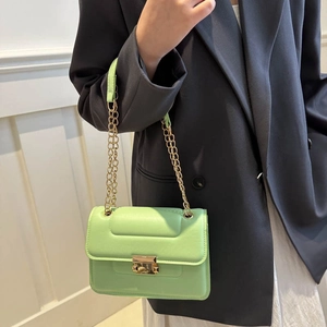Quilted mint green crossbody bag with gold chain strap shown on a model for a modern look